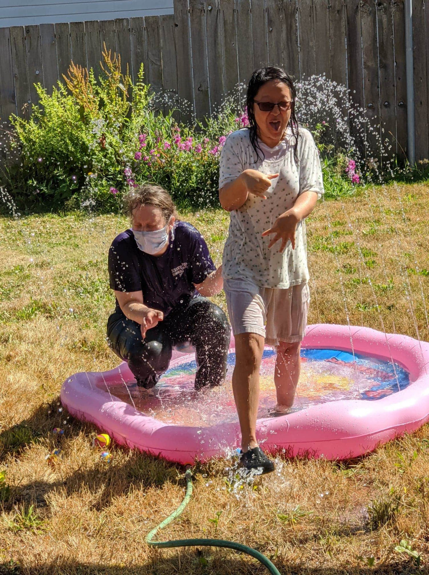 Amber and Leana running through sprinklers